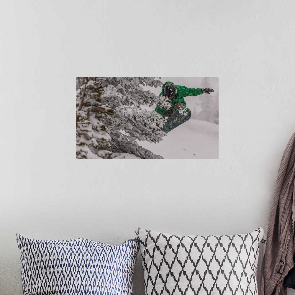 A bohemian room featuring Action shot of a snowboarder in green doing a grab mid-air.