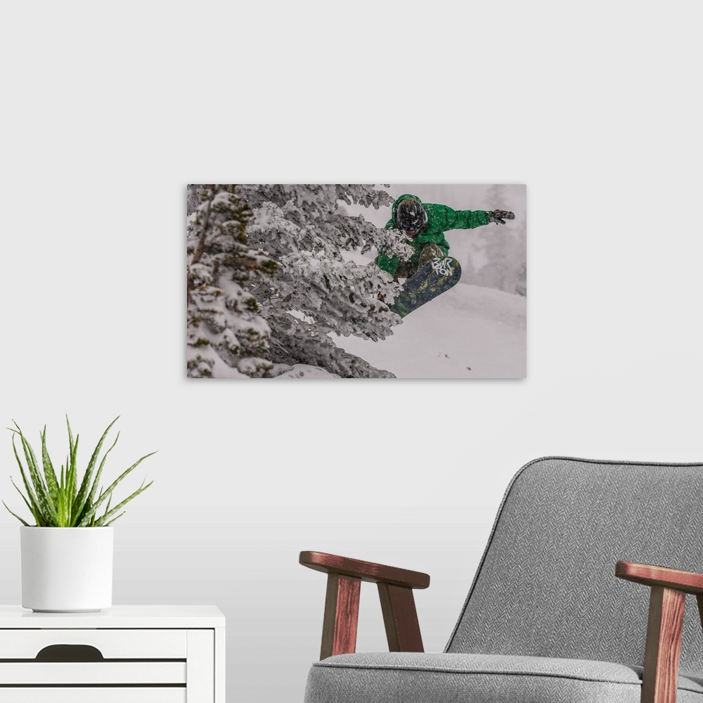 A modern room featuring Action shot of a snowboarder in green doing a grab mid-air.
