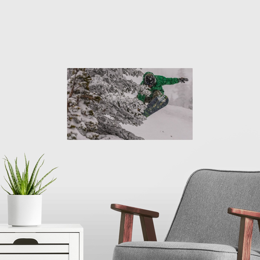 A modern room featuring Action shot of a snowboarder in green doing a grab mid-air.