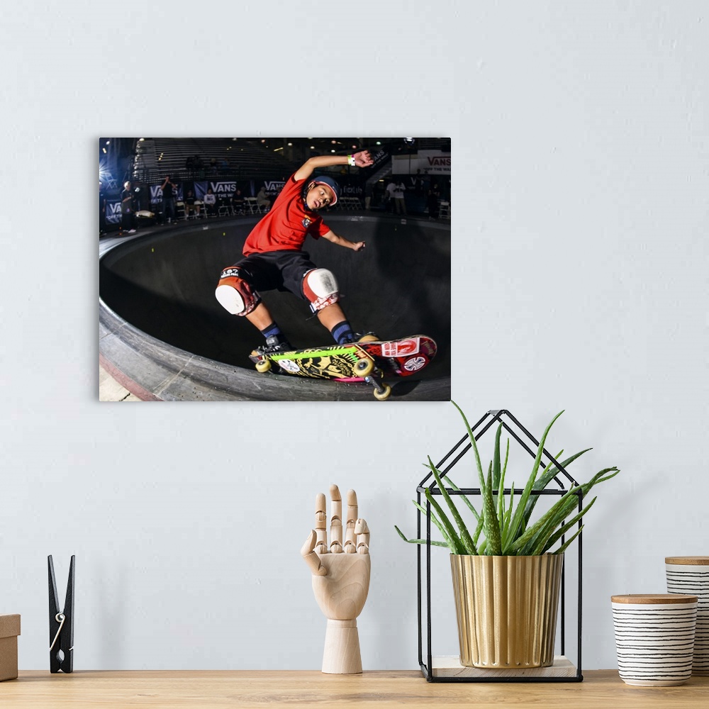 A bohemian room featuring Kiko Saucee grinding his skateboard on a railing at Vans Off The Wall Skatepark in Huntington Bea...