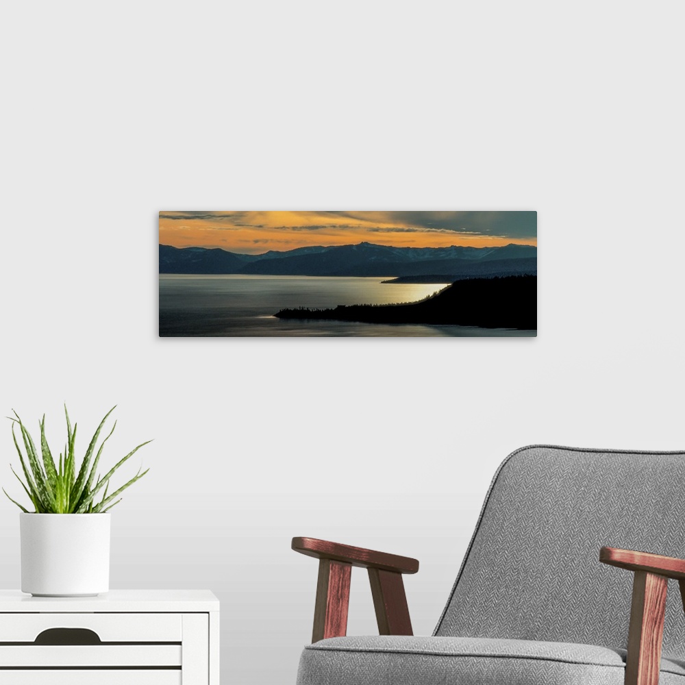 A modern room featuring Panoramic view of Lake Tahoe at dusk with sunset light in the sky, California.