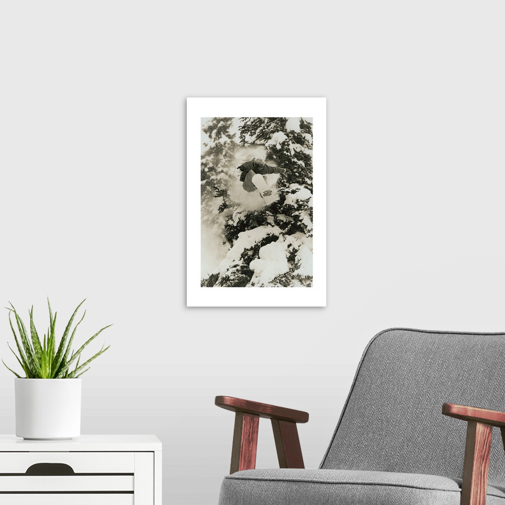 A modern room featuring Photograph of Marc Morriset snowboarding over snow covered trees in the Selkirk Mountains, Britis...