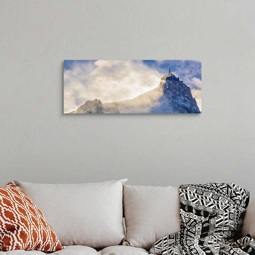 A bohemian room featuring Landscape photograph of a peak on Mont Blanc with hazy clouds.