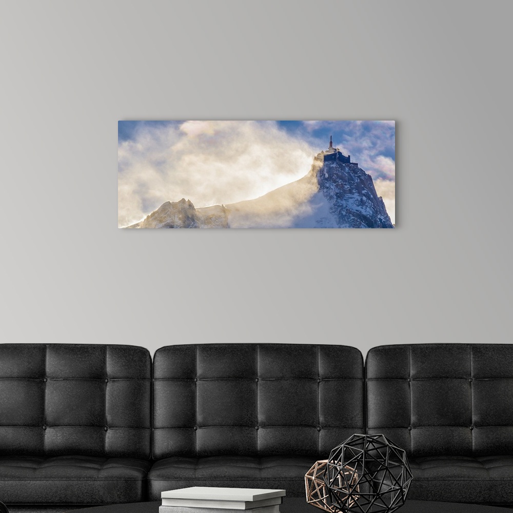 A modern room featuring Landscape photograph of a peak on Mont Blanc with hazy clouds.