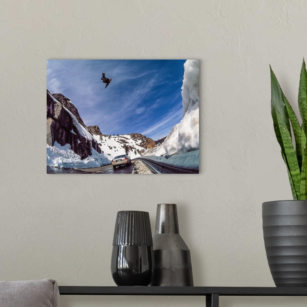 A modern room featuring Nate Mott flying on his snowboard over the Donner Summit, as a car passes by below, California, m...
