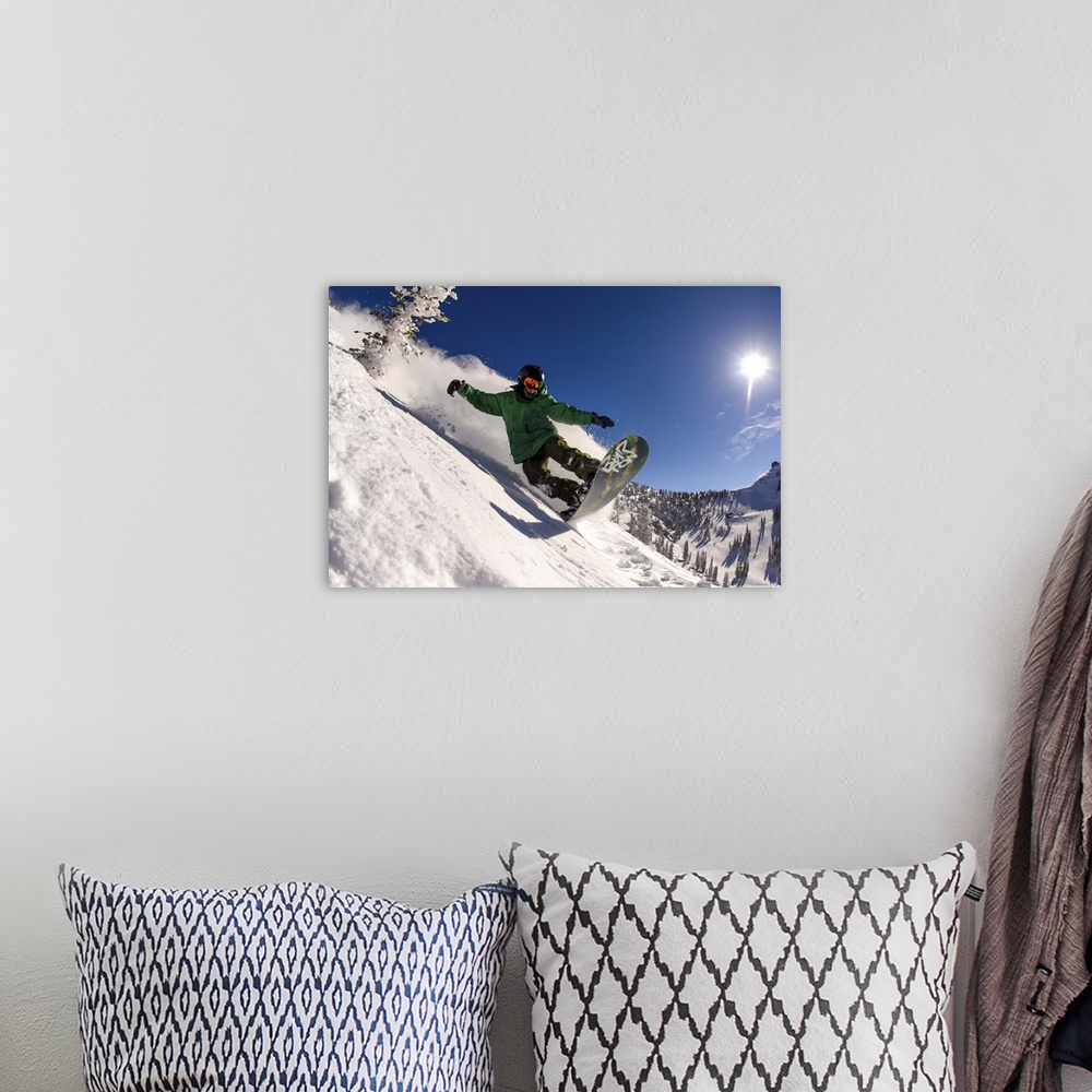 A bohemian room featuring Action shot of a snowboarder riding manual down a slope in Utah.