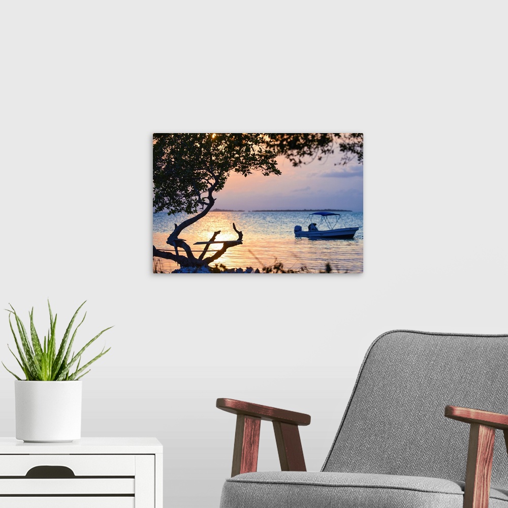 A modern room featuring Southern Belize. The sun sets over an insecure fishing perch on Buttonwood Caye in southern Belize.