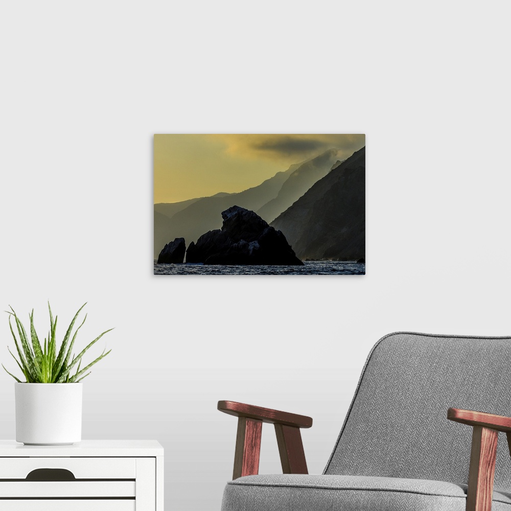A modern room featuring Catalina Island. The sun setting over the rugged backside of Catalina island.