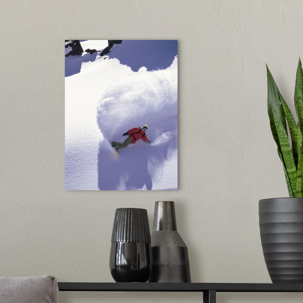 A modern room featuring Victoria Jealouse snowboarding down a mountain in Chile, creating a large cloud of powder.
