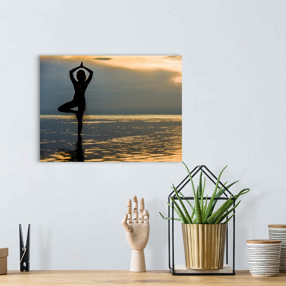 A bohemian room featuring A woman practicing Yoga on the beach in Belize in the morning.