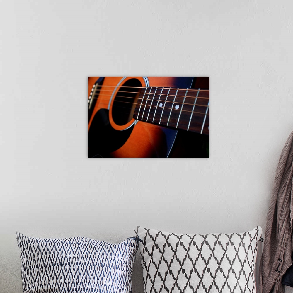 A bohemian room featuring Close up of a six string acoustic guitar.