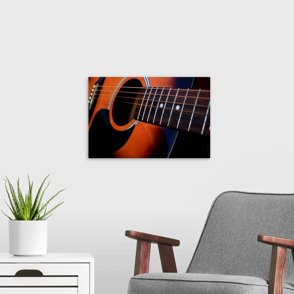 A modern room featuring Close up of a six string acoustic guitar.