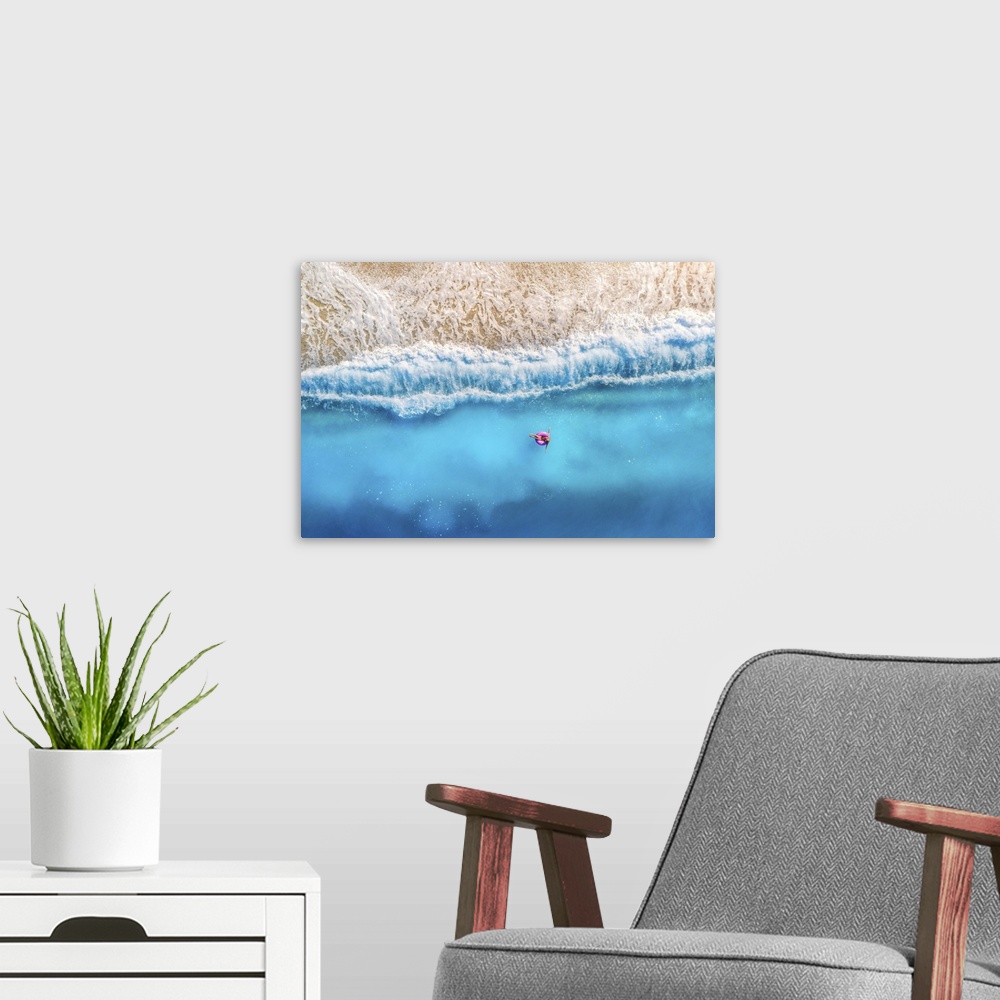 A modern room featuring Aerial View Of Woman With Donut Float In The Transparent Blue Sea At Sunset In Summer