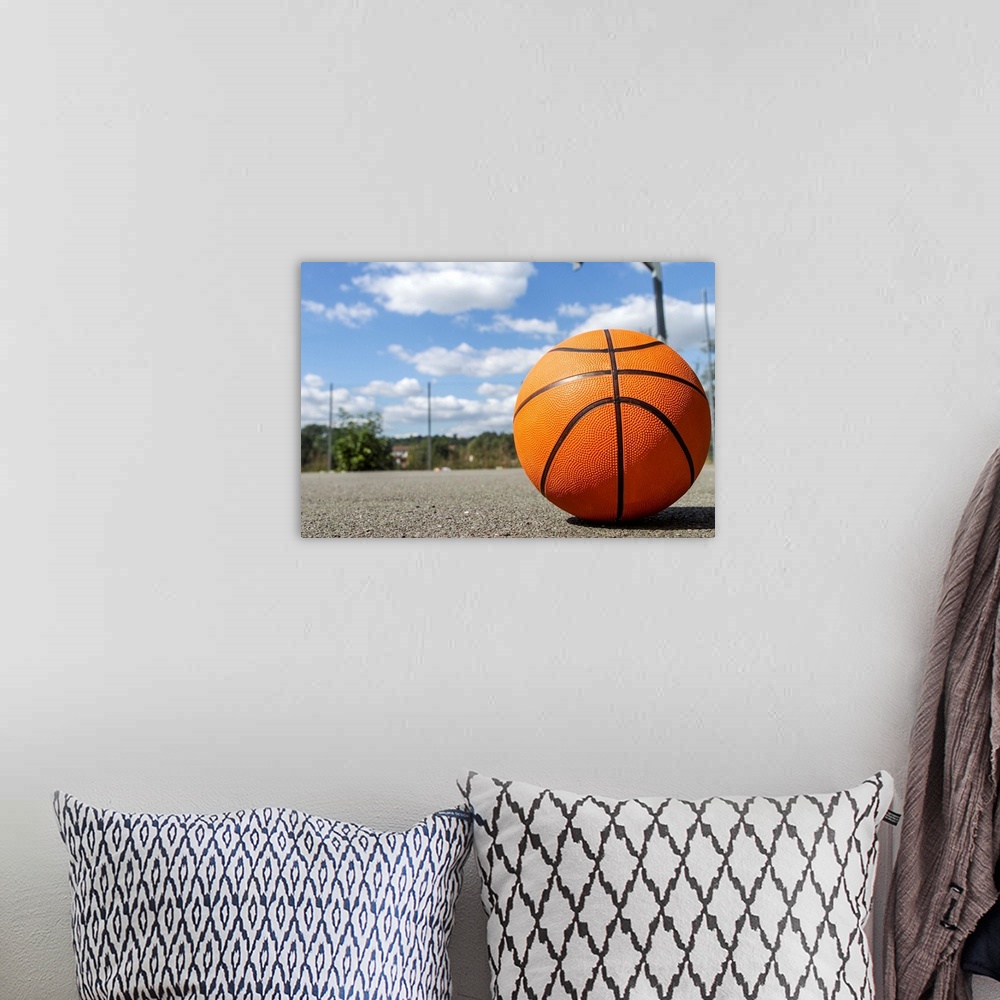 A bohemian room featuring Close up shot of a basketball on a basketball court on a sunny day.