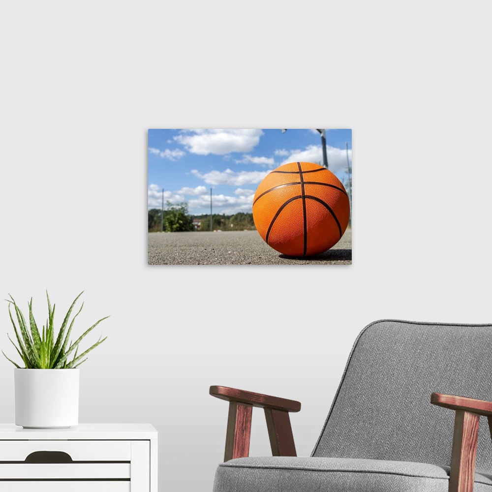 A modern room featuring Close up shot of a basketball on a basketball court on a sunny day.