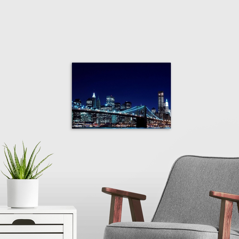 A modern room featuring Brooklyn Bridge and Manhattan Skyline At Night, New York City.