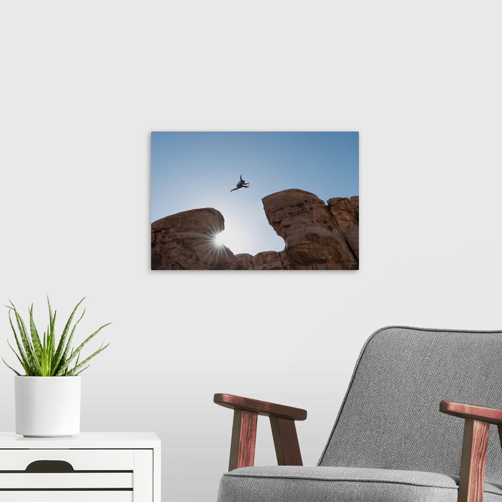 A modern room featuring Challenge, risk and freedom concept. Silhouette a man jumping over precipice crossing cliff.