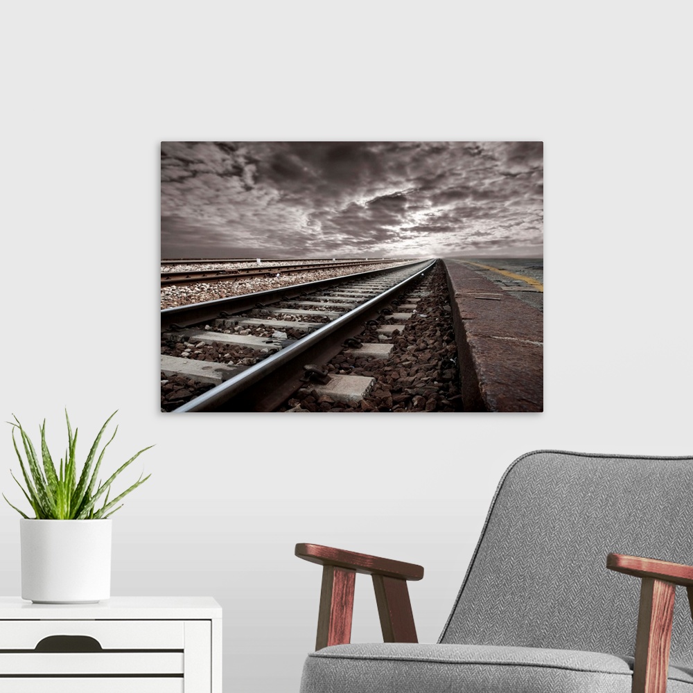 A modern room featuring empty railway tracks in a stormy landscape
