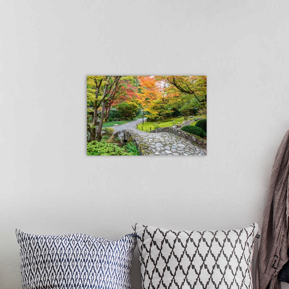 A bohemian room featuring Autumn colors along a winding walking path and stone bridge in a Japanese garden.