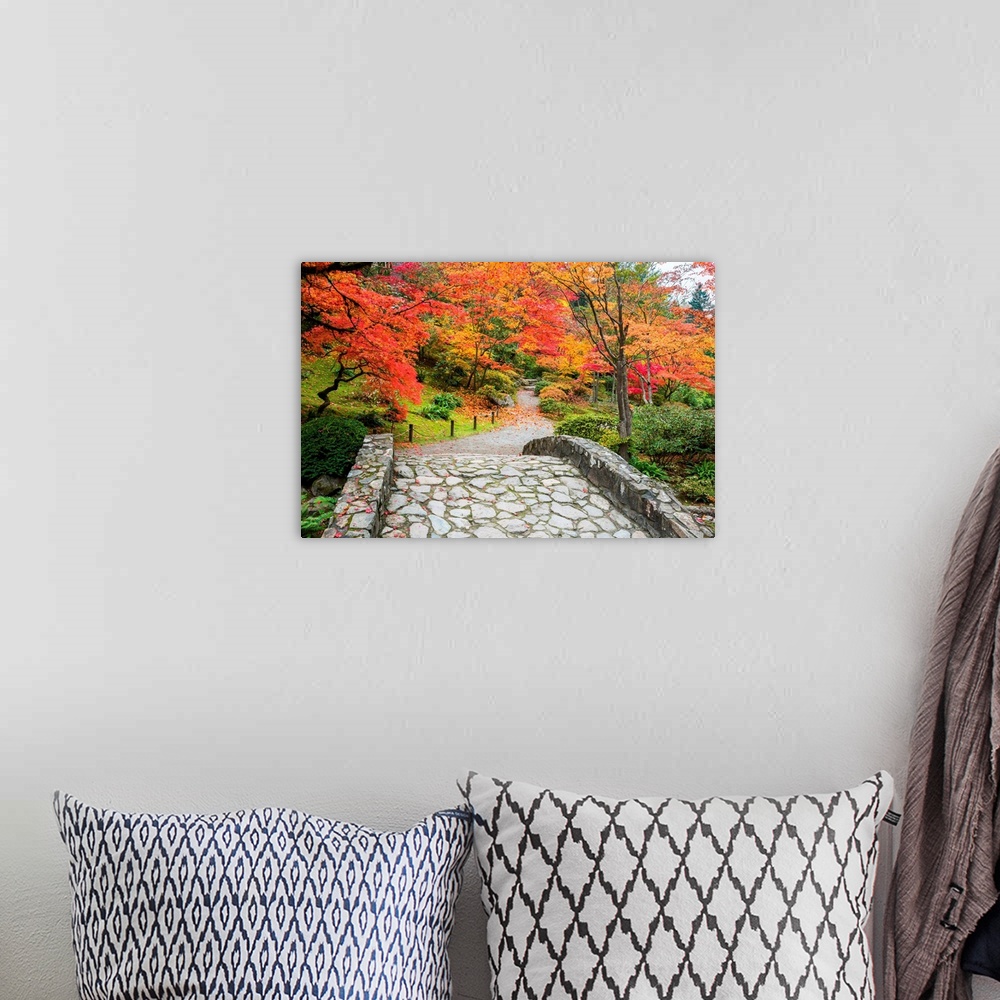 A bohemian room featuring Stone bridge and winding walking path through garden with trees in autumn colors.