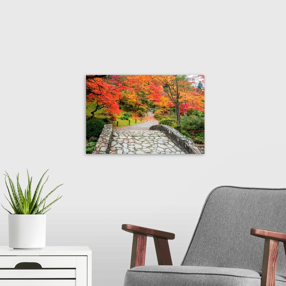 A modern room featuring Stone bridge and winding walking path through garden with trees in autumn colors.