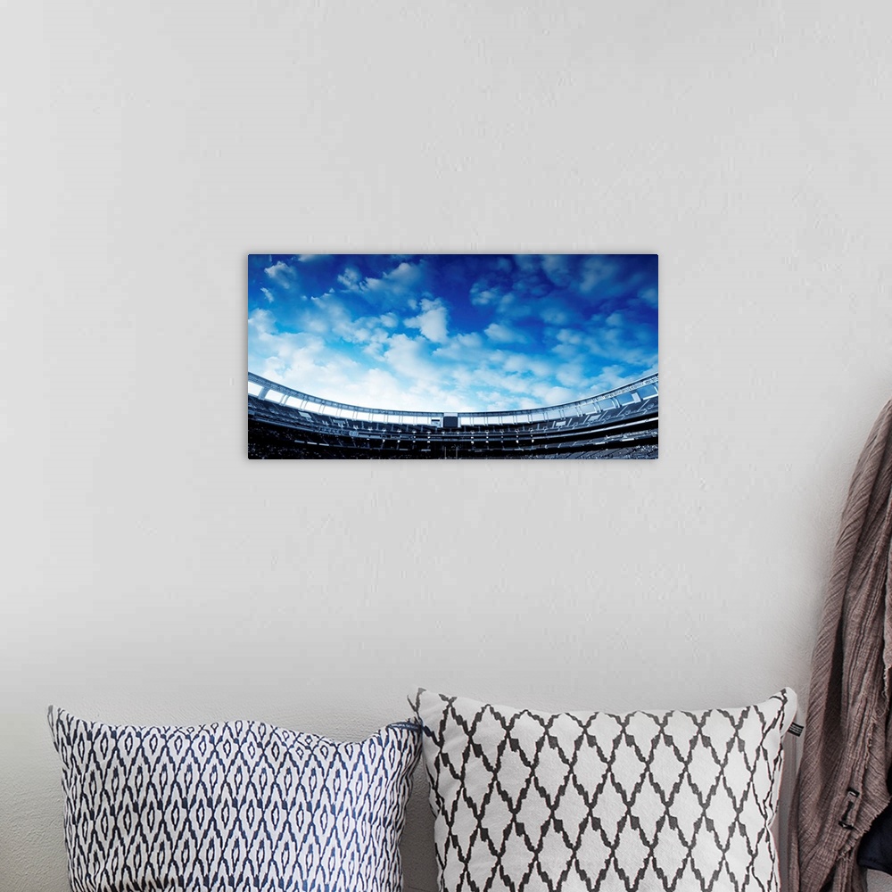 A bohemian room featuring Wide Horizontal photo of a american football stadium with blue clouds in the sky.