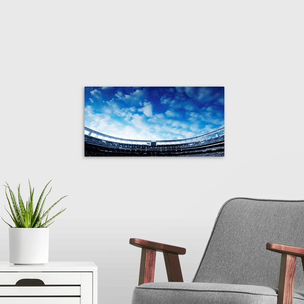 A modern room featuring Wide Horizontal photo of a american football stadium with blue clouds in the sky.