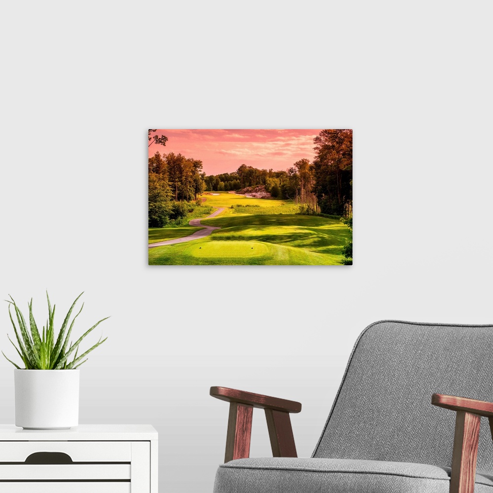 A modern room featuring Golf course bathed in light of a sunset.
