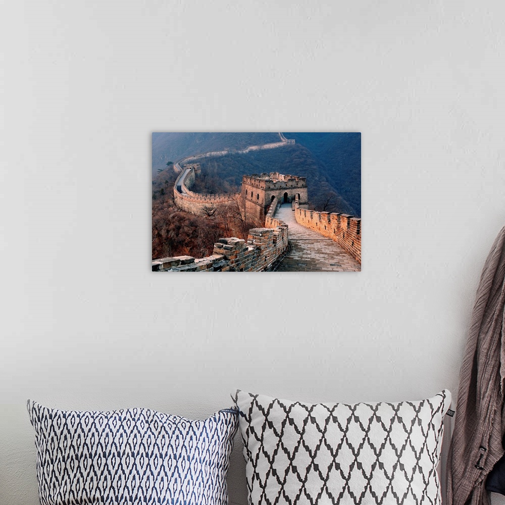A bohemian room featuring Great Wall of China at sunset in a rolling mountainous valley.