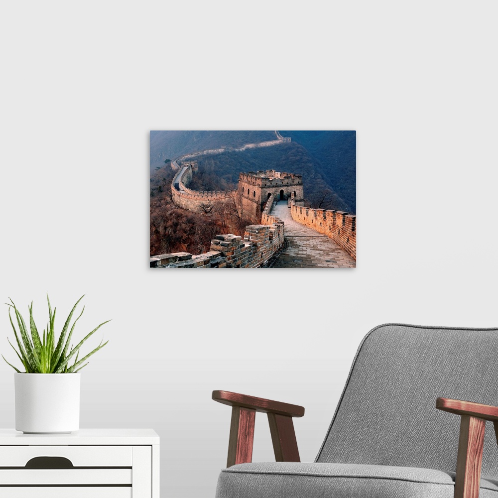 A modern room featuring Great Wall of China at sunset in a rolling mountainous valley.