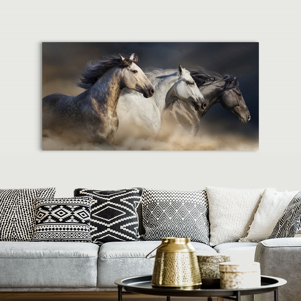 A bohemian room featuring Portrait of horses with long manes galloping in desert dust.
