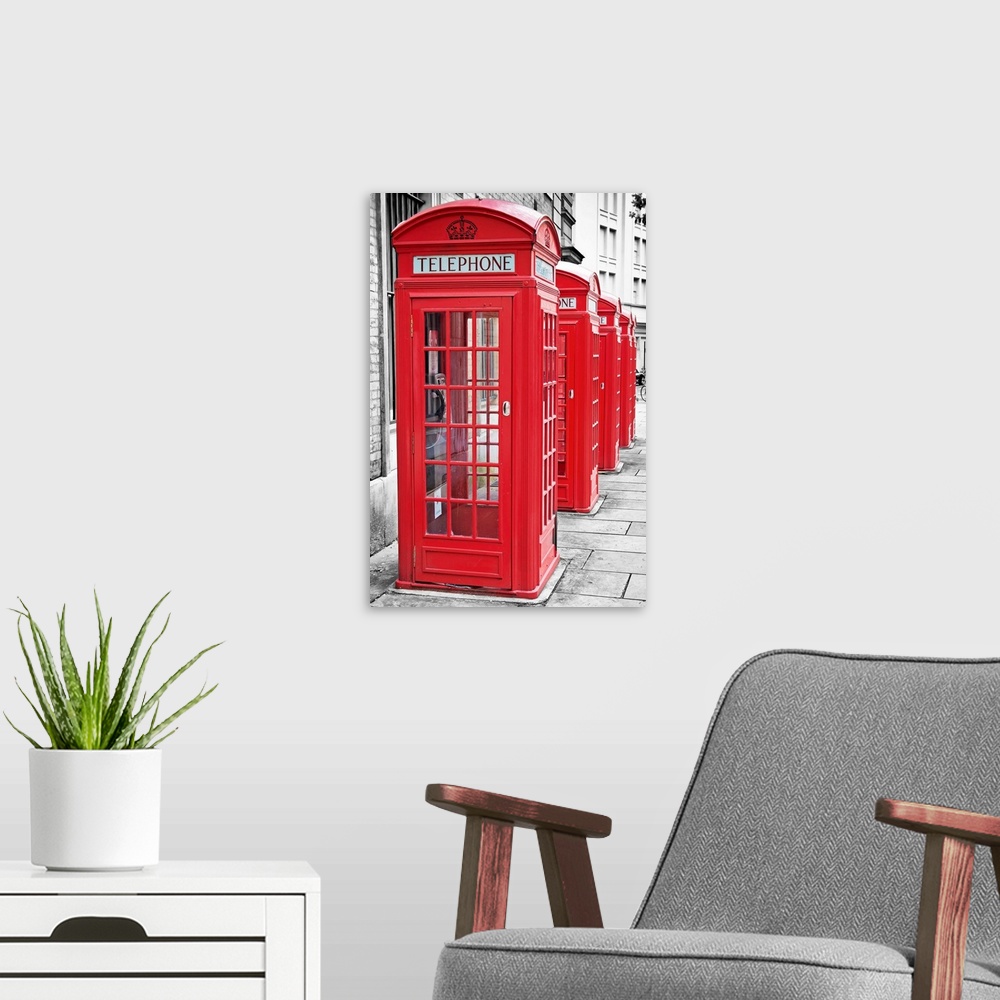 A modern room featuring Row of iconic London red phone cabins with the rest of the picture in black and white