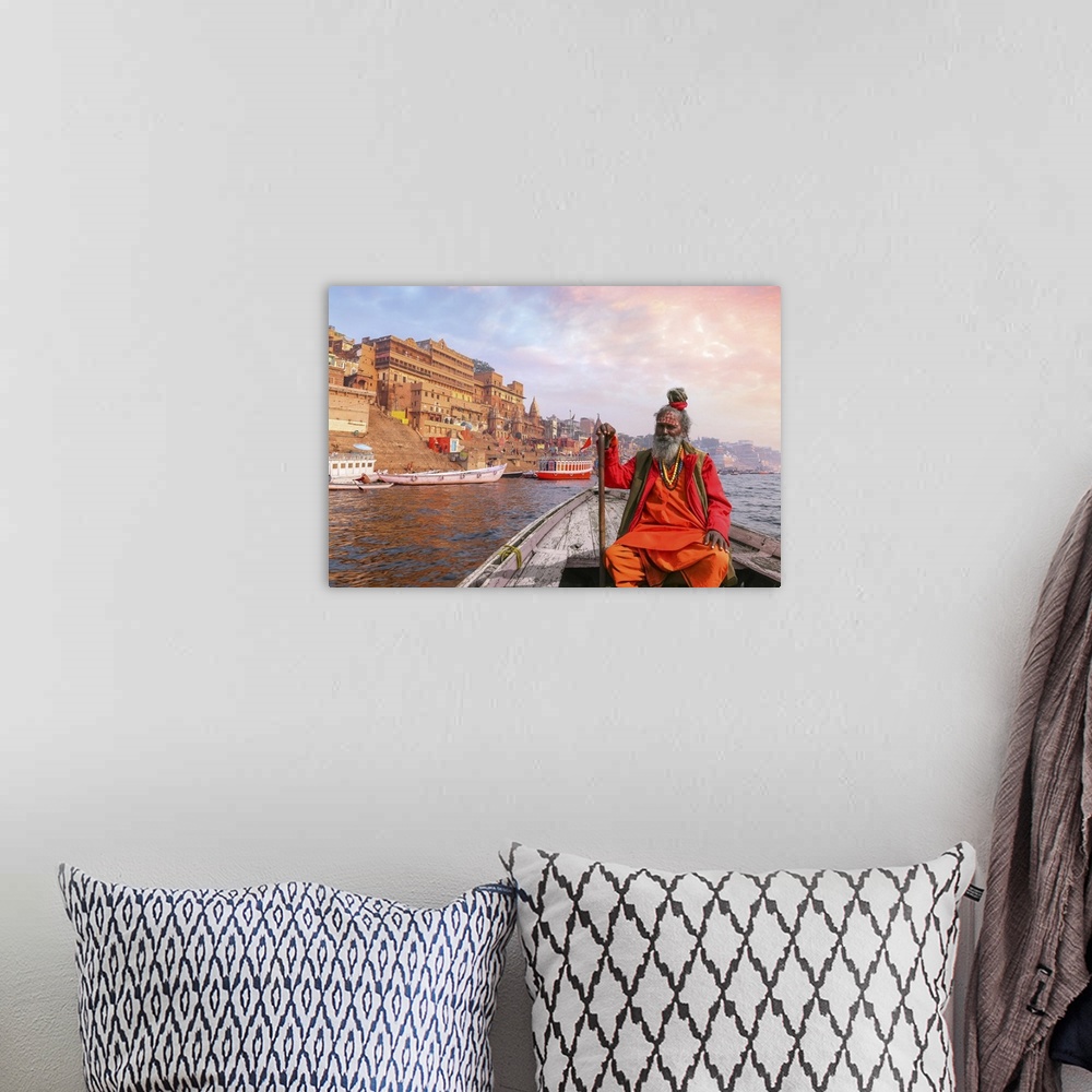 A bohemian room featuring Indian Sadhu Baba Takes A Boat Ride On River Ganges Overlooking Varanasi City At Sunset