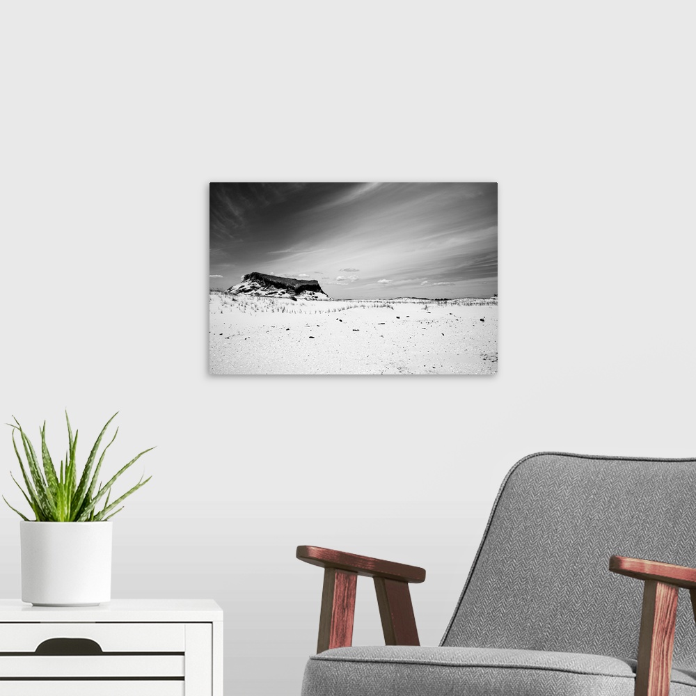 A modern room featuring A black and white shot of a Jersey Shore sand dune against a cloud streaked sky at Island Beach S...