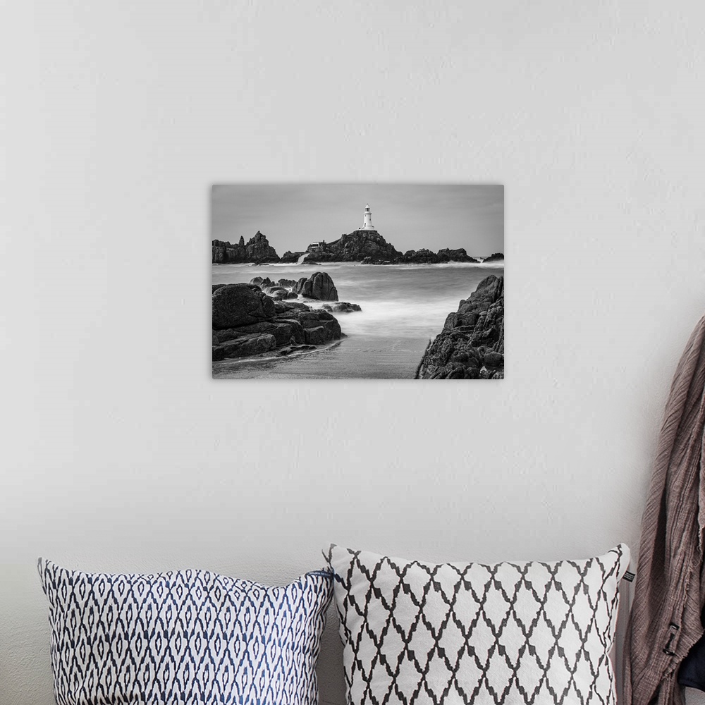 A bohemian room featuring High tide covers the causeway leading to La Corbiere lighthouse, Jersey, Channel Islands, UK.