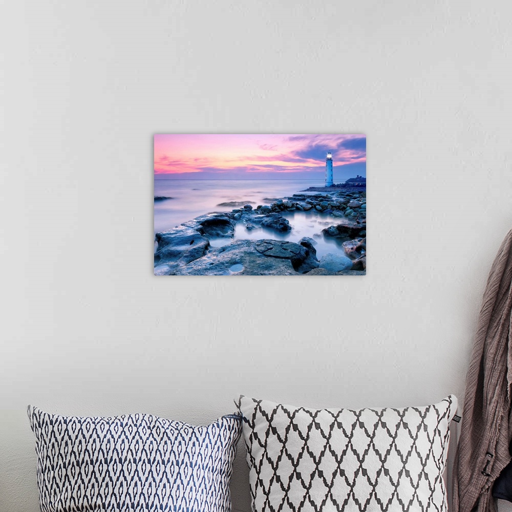 A bohemian room featuring Lighthouse On Rocky Coastline At Sunset.