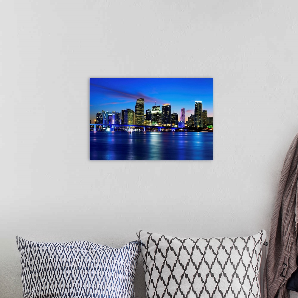 A bohemian room featuring Miami city skyline panorama at dusk with urban skyscrapers over sea with reflection.