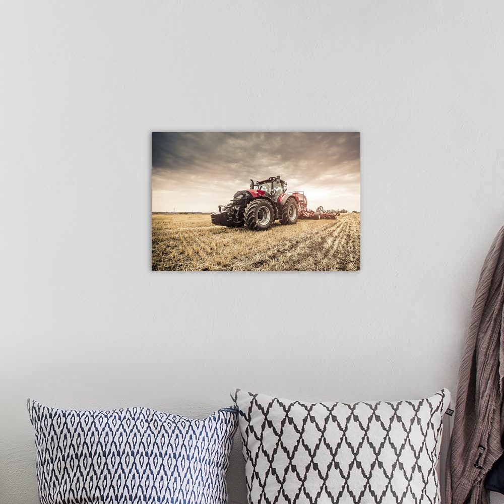 A bohemian room featuring Modern red tractor seeding directly into the stubble with red equipment using GPS for precision f...