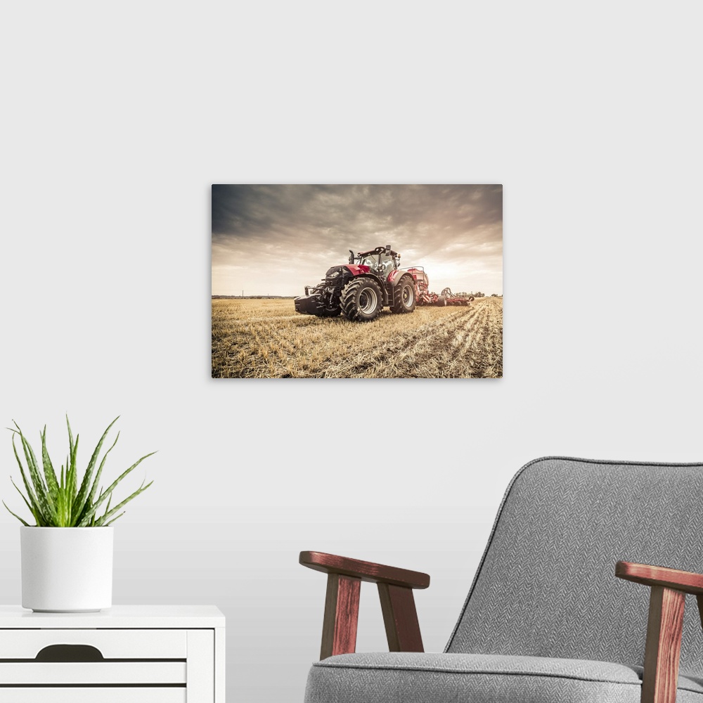 A modern room featuring Modern red tractor seeding directly into the stubble with red equipment using GPS for precision f...