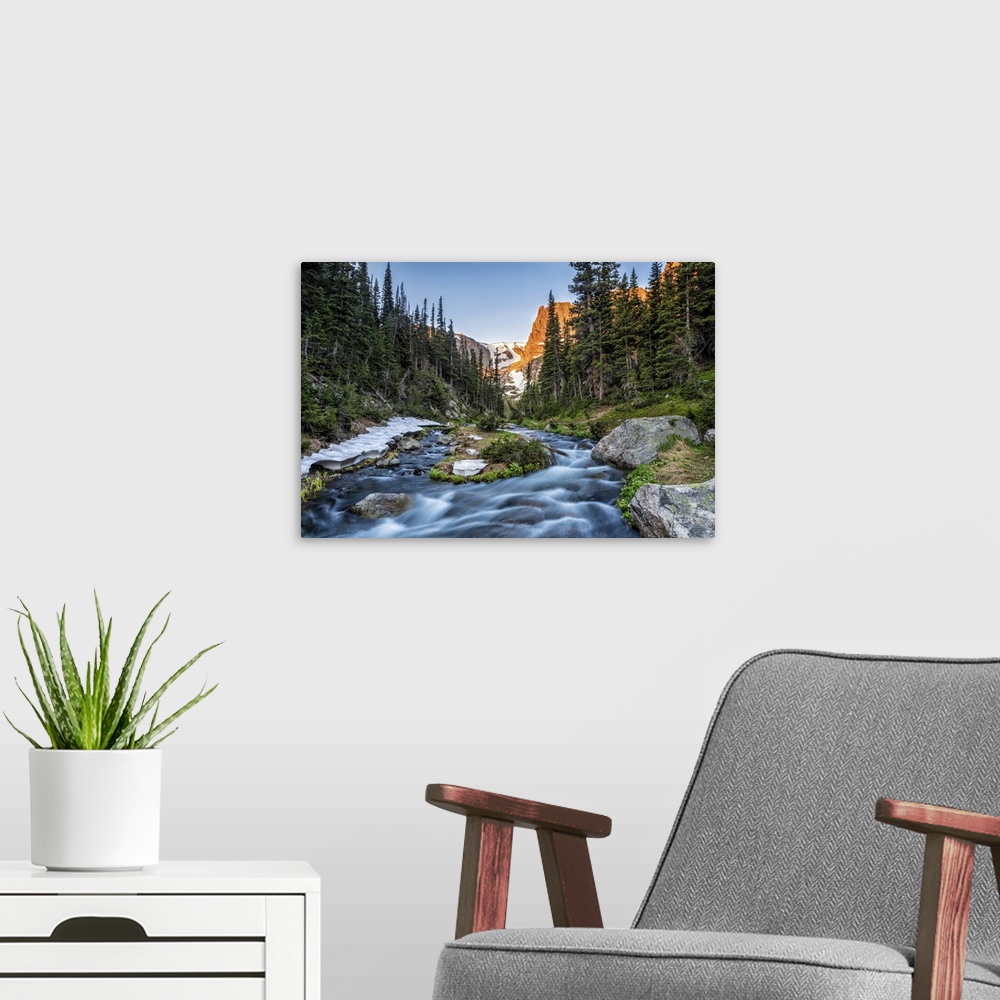 A modern room featuring Fern creek flows out of Odessa Lake below Notchtop Mountain and the Ptarmigan Pass seen through t...