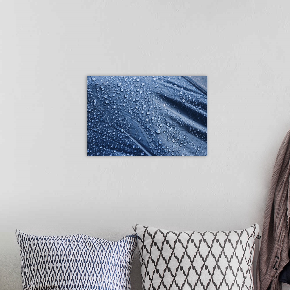 A bohemian room featuring Water drops on the fabric. Rain water droplets on blue fiber waterproof fabric. Water drops patte...