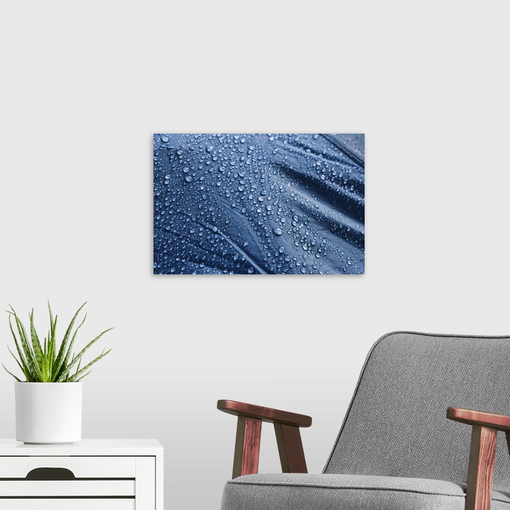 A modern room featuring Water drops on the fabric. Rain water droplets on blue fiber waterproof fabric. Water drops patte...