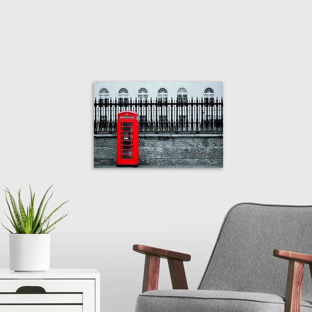 A modern room featuring Red telephone box in street with historical architecture in London.