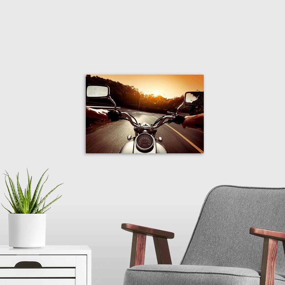 A modern room featuring Driver riding motorcycle on an asphalt road through forest