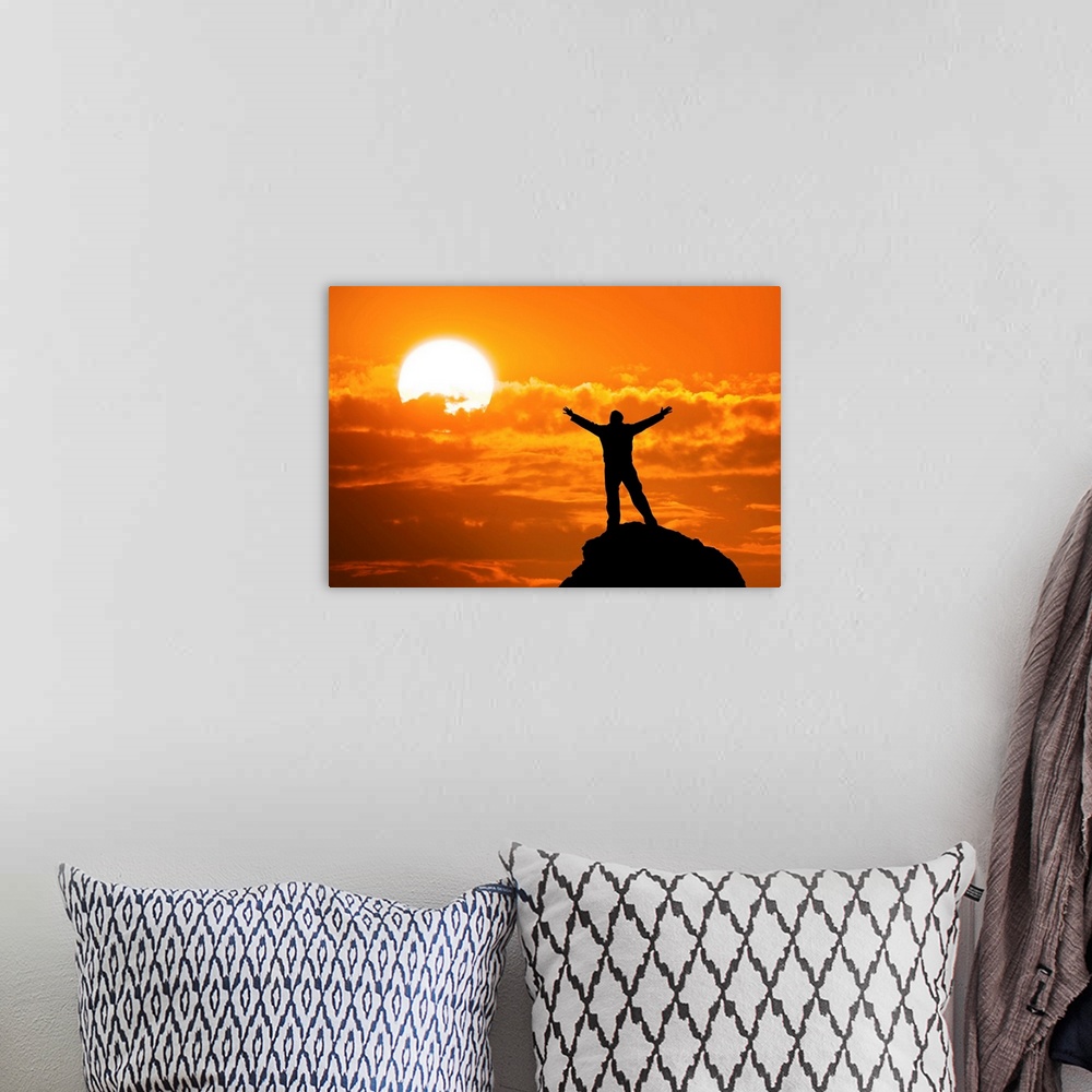 A bohemian room featuring Silhouette of man on mountain peak with arms outstretched looking at the sun