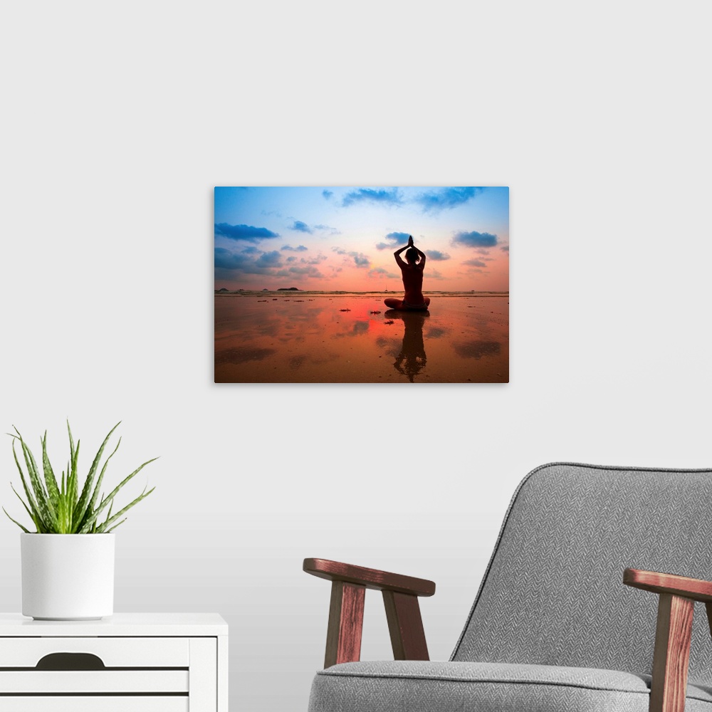A modern room featuring Silhouette of woman practicing yoga on the beach at sunset