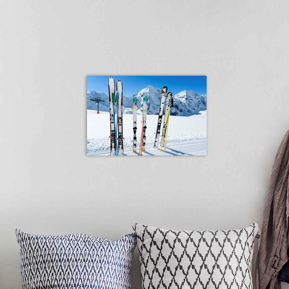 A bohemian room featuring Skis sticking in the snow on a mountain slope..