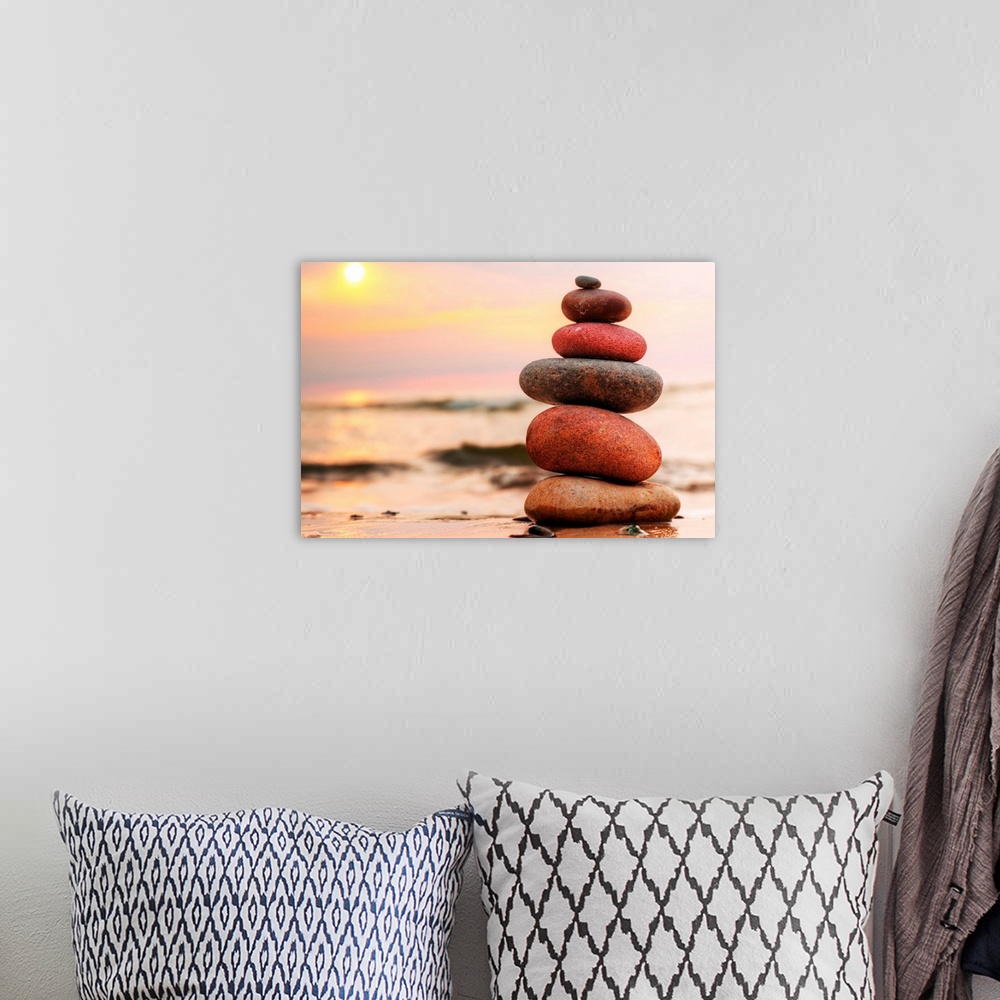 A bohemian room featuring Stacked stones on a beach at sunset.
