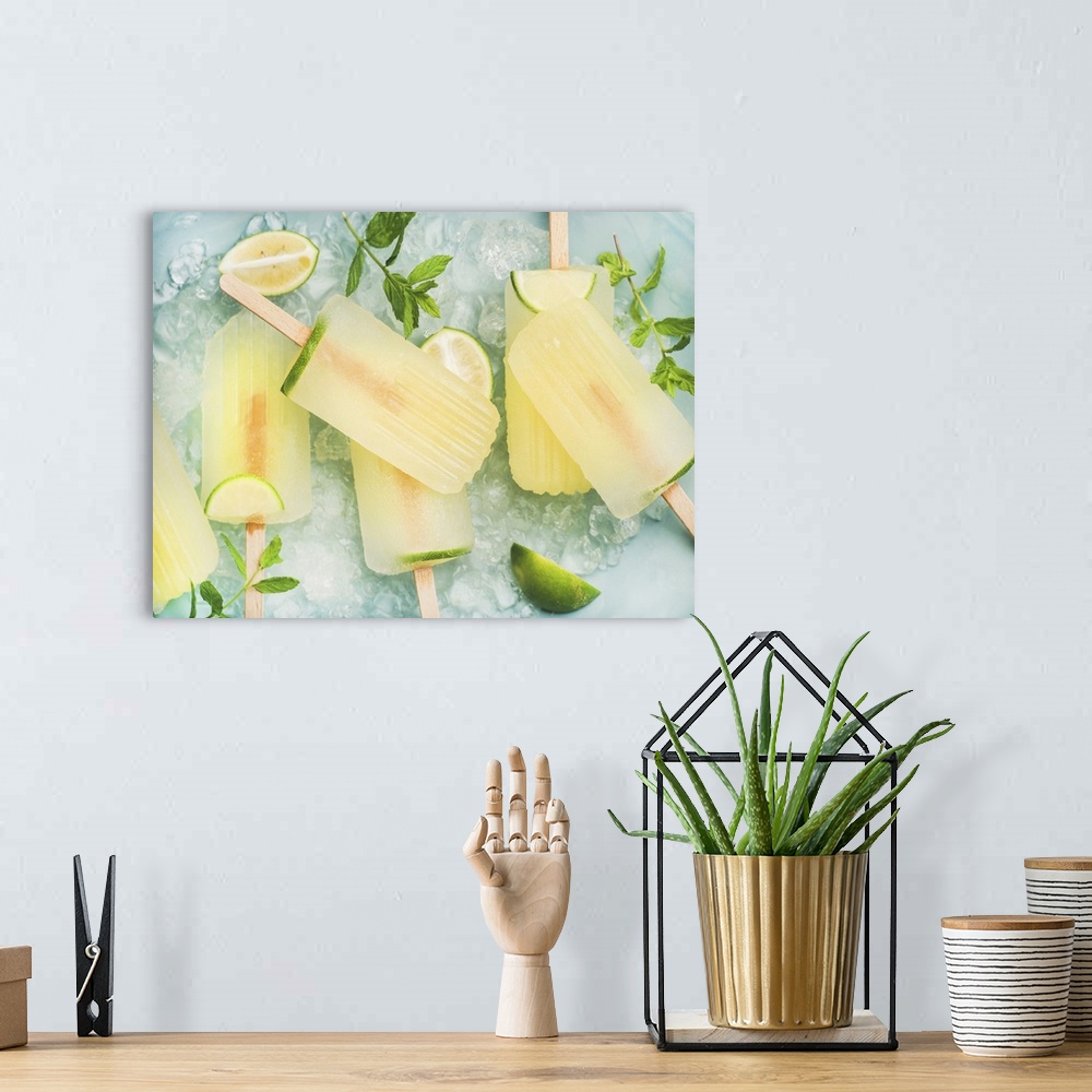 A bohemian room featuring Summer refreshing lemonade popsicles with lime and mint with chipped ice over blue background, to...
