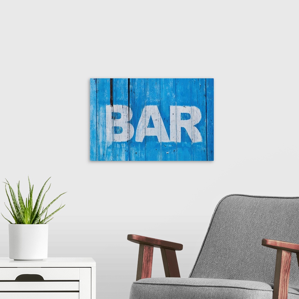 A modern room featuring White bar sign painted on a dilapidated blue wooden wall